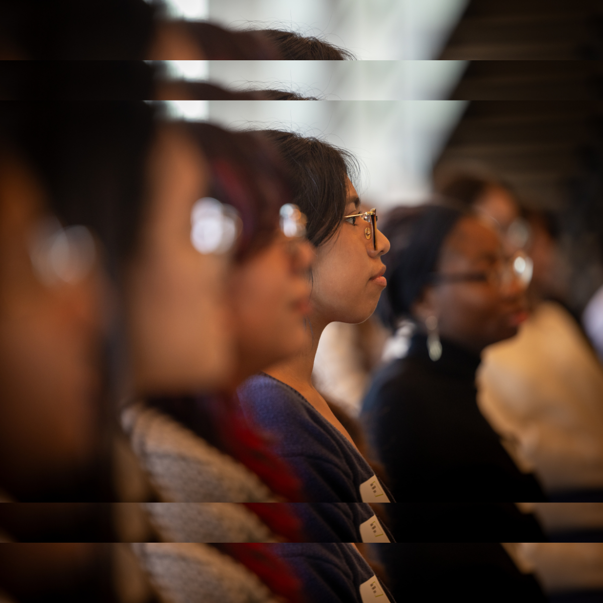 A blurred photo of three Break Through Tech fellows sitting side by side.