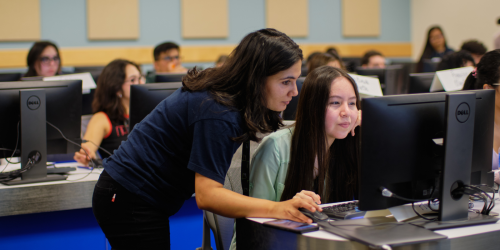 A student works with an instructor at a computer.